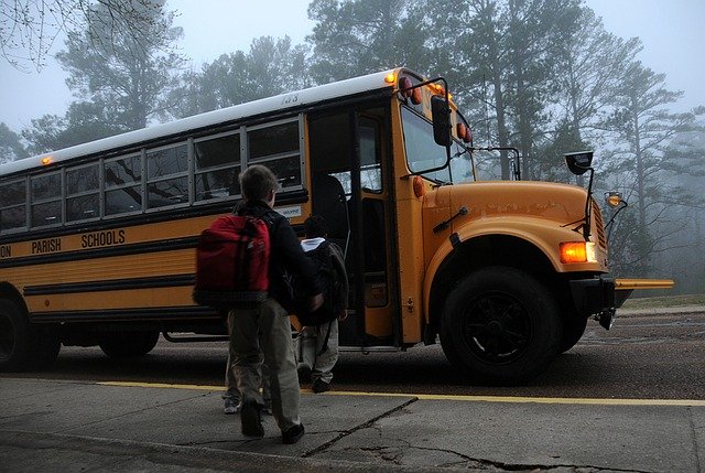 момче с ученическа раница в гръб върви към училищния автобус
